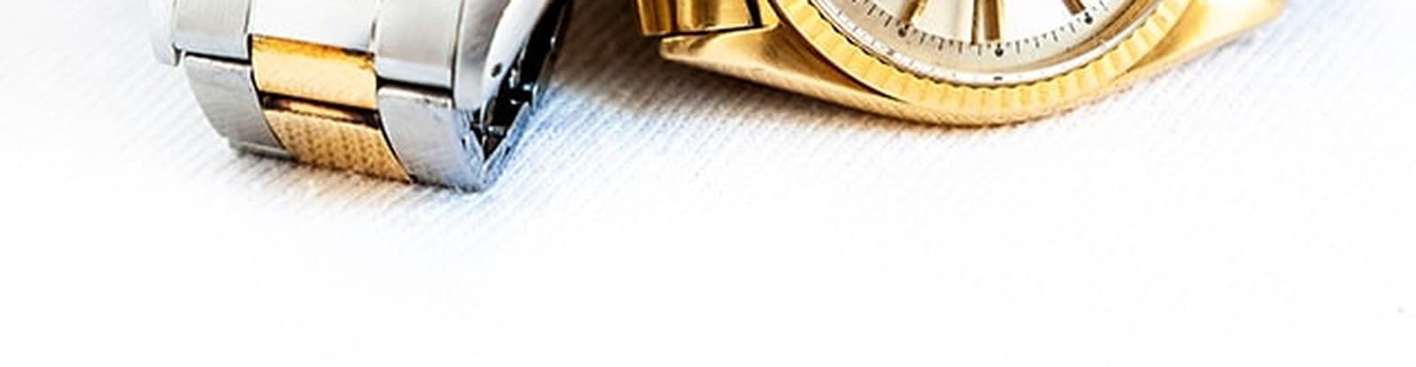 Close detail of two pre-owned watch bracelets resting on a light surface
